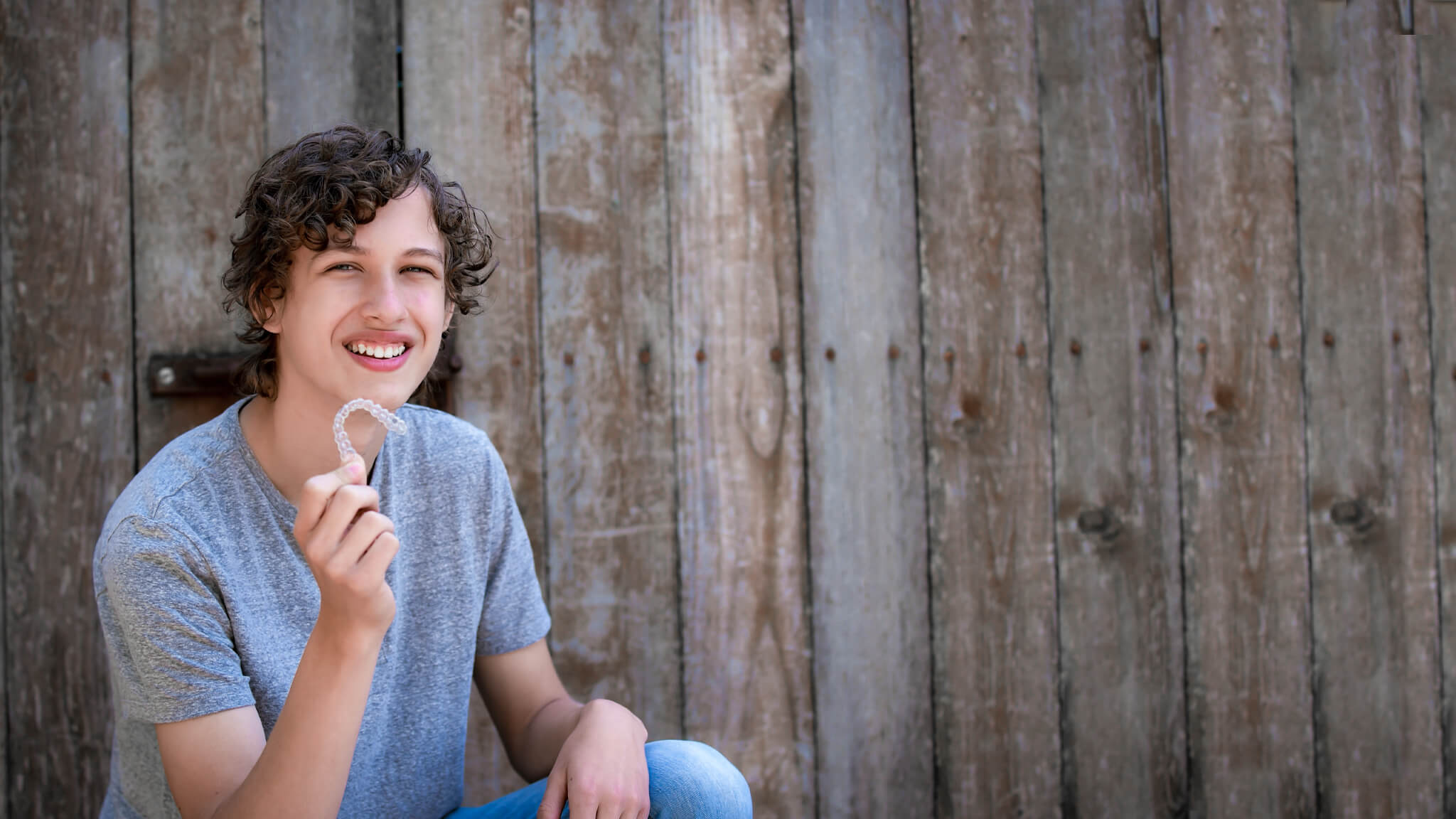 boy smiling with an invisalign aligner