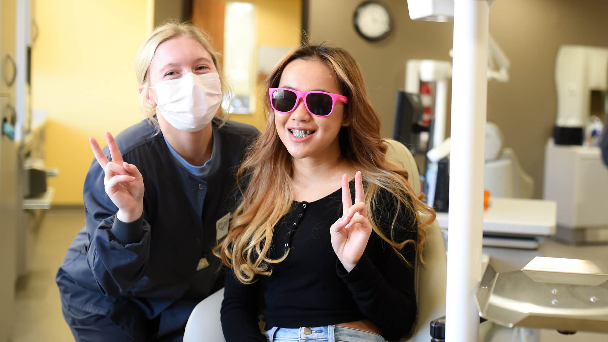 young patient with team member throwing peace signs